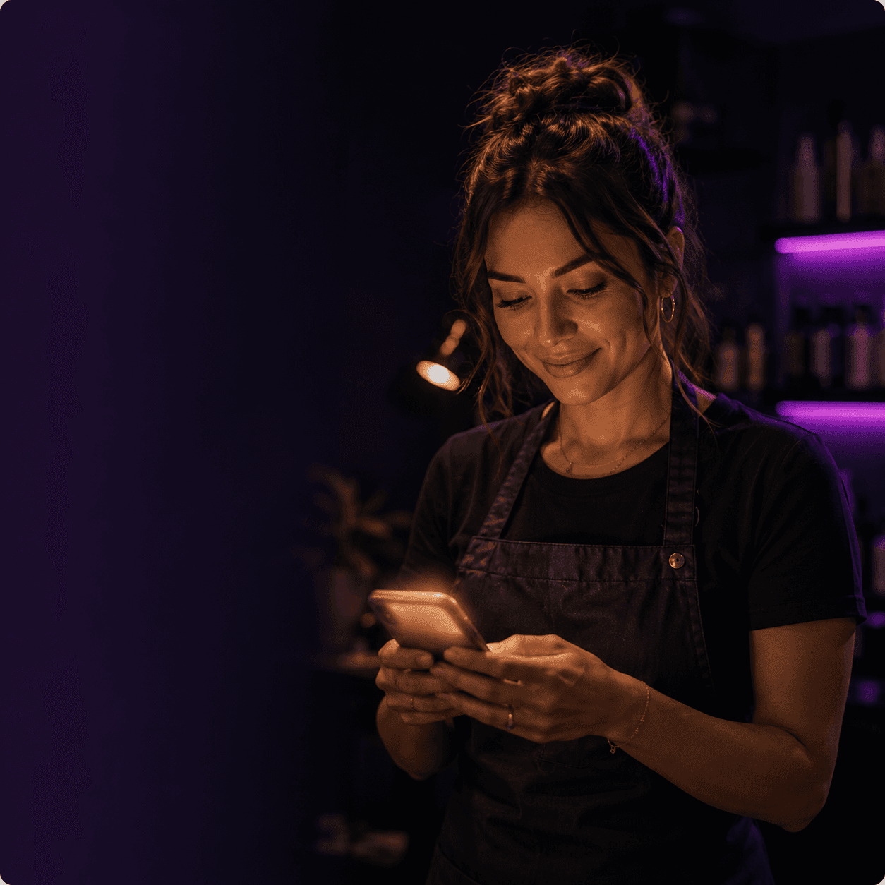 Beauty professional smiling at her phone in her studio